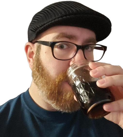 Jeff, wearing glasses and a beret, with a short beard, drinking coffee.